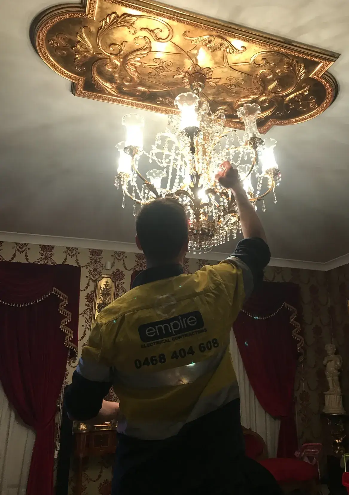 Empire electrician installing a chandelier in a Sydney home